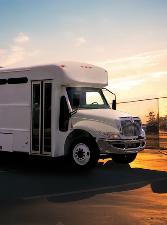 White shuttle bus parked next to a security fence at a prison near Dallas Fort Worth